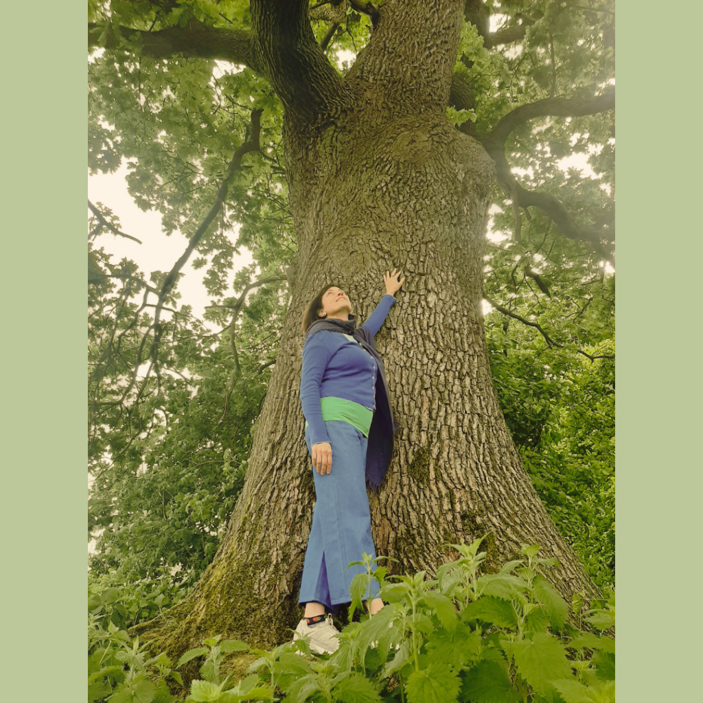 Frau legt Hand auf einen alten Baum